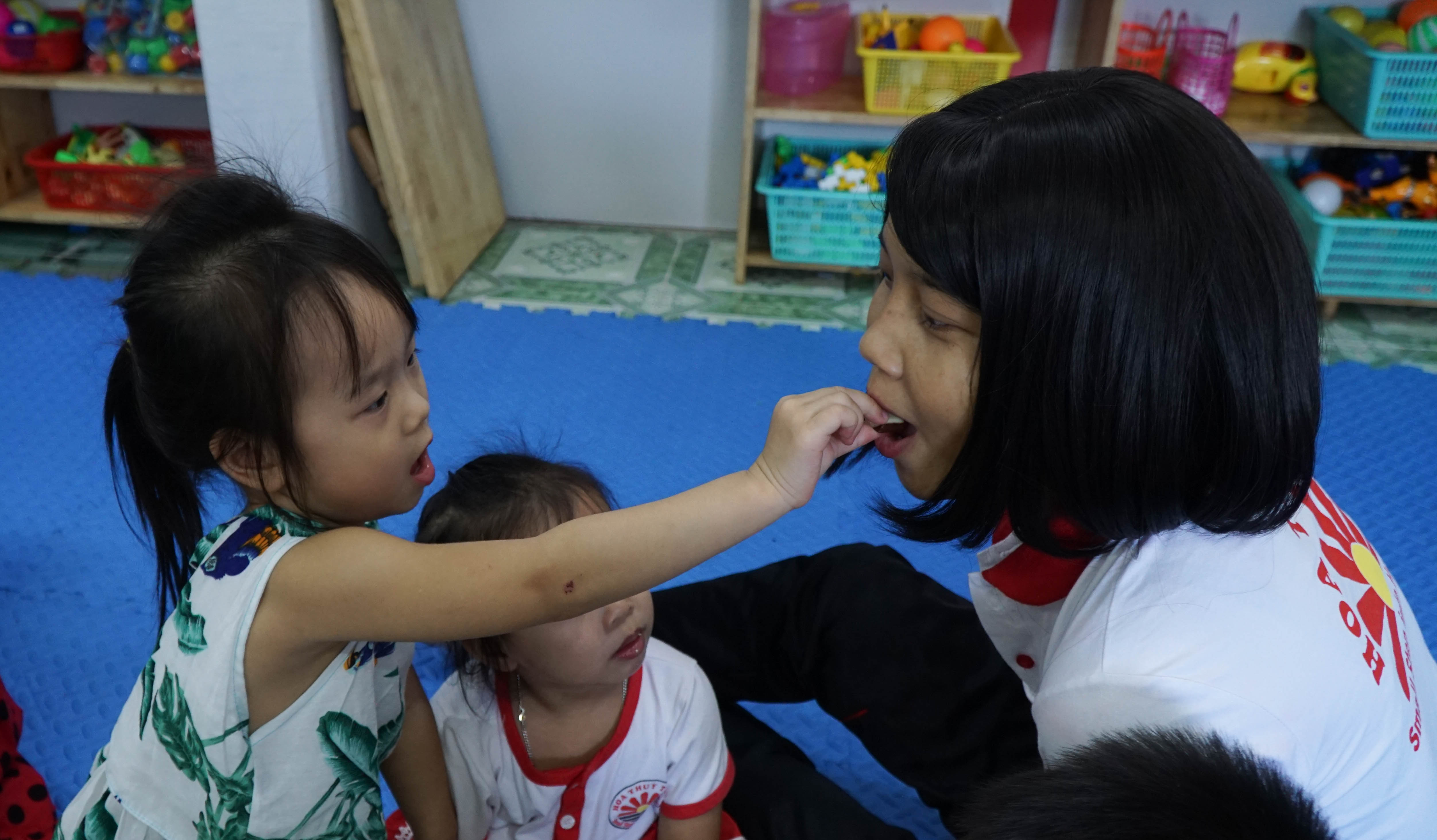 Các em đút kẹo cho cô Mai Ly.